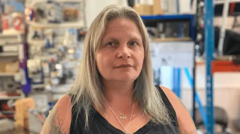 Charlotte Wright Close-up picture of Julie Wright, from Clarkewrights Mobility with the shop behind her