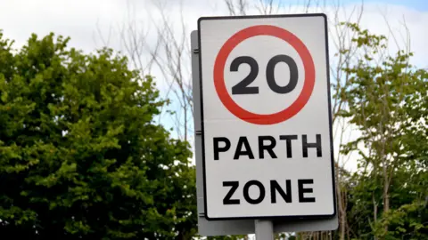 Getty Images A 20mph sign with trees in the background. 