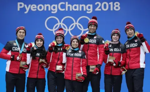 Andreas Rentz/Getty Images The Canadian skating team pose with their gold medals