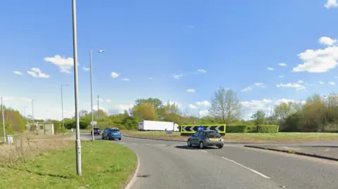 Google A car's eye view of vehicles approaching the roundabout, which has black and white chevrons on with neon edging.