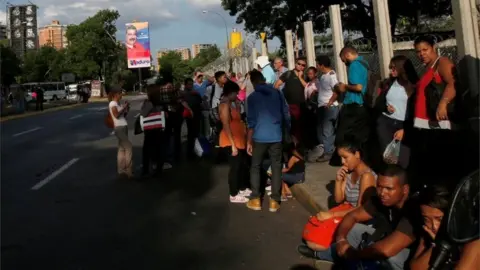 Reuters Venezuela's President Nicolas Maduro campaign posters for the 2018 presidential elections is seen in the street as people wait for a bus in Caracas, Venezuela May 11, 201