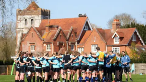 Catherill Ivill/The RFU Collection/Getty Images England Red Roses pictured in a huddle during a training session at Bisham Abbey on 20 April 2023