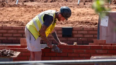 A man building a wall at a housing construction site