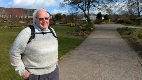 A photo of John Harkin, an elderly man with grey hair, at a park.