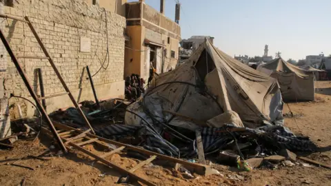 Reuters Damaged tent following Israeli air strike on an area near al-Awda school in Abasan al-Kabira where displaced people were sheltering, in southern Gaza (10 July 2024)