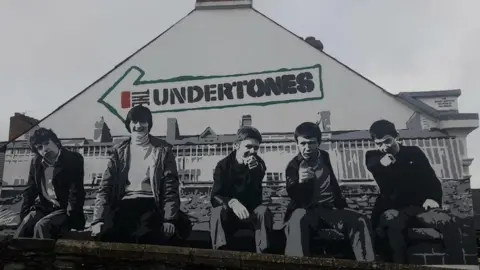A mural of Derry punk band the Undertones, recreating their debut album cover, on a city centre gable wall