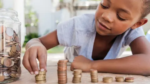 Getty Images Child counting coins