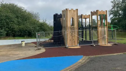 Robbie Kalus/BBC Wooden play structure in the park