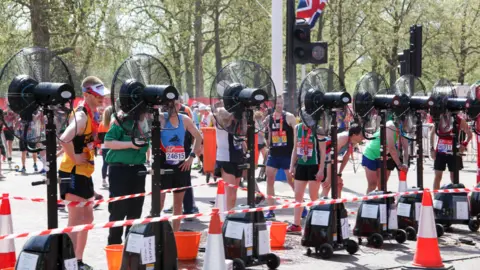 Runner stand in front of fans after taking part in London Marathon