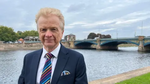 Rushcliffe Borough Council leader Neil Clarke with Trent Bridge in the background