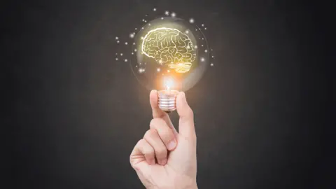 Getty Images A hand holding a light bulb containing a brain