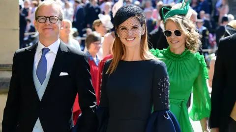 PA Sarah Rafferty in an embellished navy dress and hat