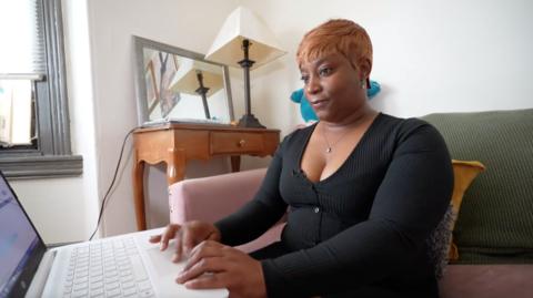 Stacey Ellis looks at a computer