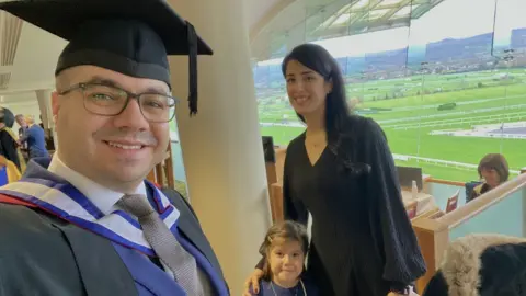 Mohamed Hady Taresh at his graduation with his wife and daughter