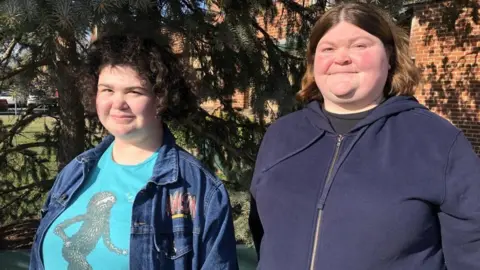 BBC Mother and daughter stand with a tree in the background