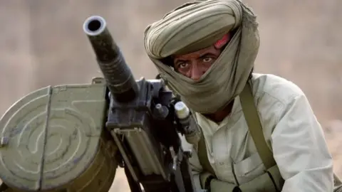 Getty Images A Marri tribal guerrilla prepares to fire a grenade launcher at a Pakistani troop outpost January 31, 2006 near Kahan in the Pakistani province of Balochistan.
