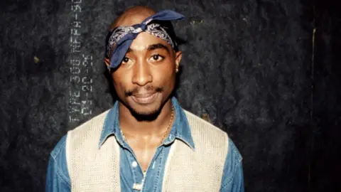 Tupac Shakur poses for photos backstage after his performance at the Regal Theater in Chicago, Illinois in March 1994. 