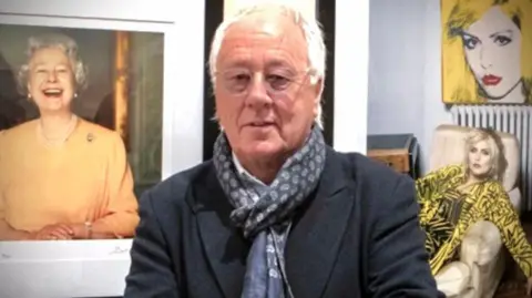 Brian Aris The image shows a man wearing a jacket and scarf, with photographs of women including Queen Elizabeth II.