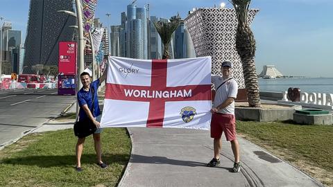 Aaron Hacon and Lee Nash hold up Worlingham flag in Doha