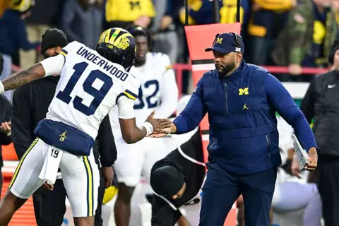 University of Michigan Wolverine's head coach Sherrone Moore congratulates a player as the Wolverine's faced the University of Maryland in November