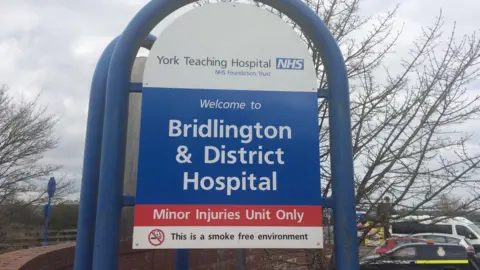 The sign outside Bridlington Hospital. The sign reads "Welcome to Bridlington & District Hospital. Minor Injuries Unit Only. This is a smoke free environment".