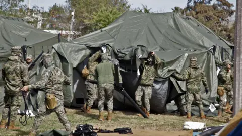 Getty Images Mexican official erect tents to house migrants