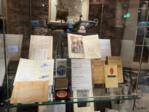 A selection of documents in a glass display case.