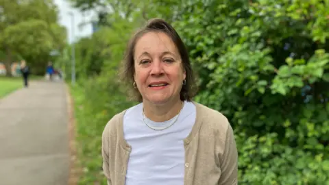 Louise Stead, Group Chief Executive of Ashford and St Peter's and Royal Surrey NHS Foundation Trusts, looks straight at the camera 