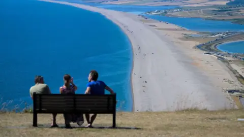 Getty Images People sunbathing near Chesil Beach in Portland