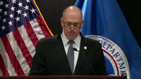 Tom Homan is talking to the press.