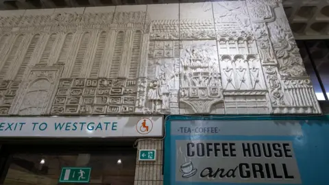 A large stone-effect mural in a shopping centre.
