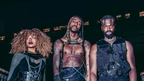 Brits Fringe handout Rock rap trio Third Kulture wearing black leather look outfits and silver chains in a publicity shot.