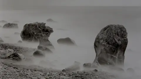 Estate of John Blakemore, Courtesy Centre for British Photography A work by John Blakemore featuring mist surrounding larger stones on a pebble beach