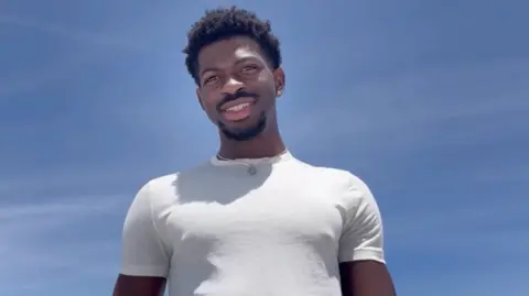 Lil Nas X pictured in a white t-shirt against a clear blue sky, in a screengrab from his Instagram statement