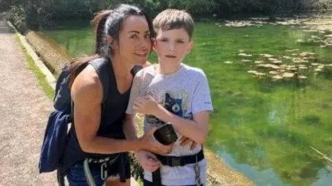 Family handout Joanne and her son Harry are wearing the harness while on a walk on a summer's day. 