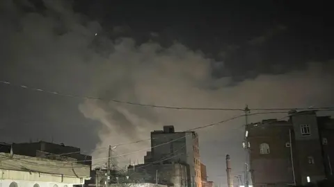 Getty Images The smoke increased after the American-Israeli planes launched a series of air strikes on the capital, Sanaa, Yemen on March 15, 2025. 