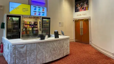 Sophia Luis-Hobbs/BBC A small bar and kiosk in a theatre.