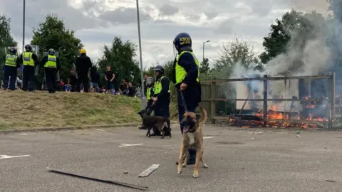 BBC A police dog outside the Holiday Inn Express hotel in Manvers