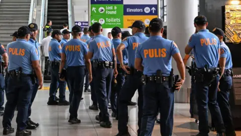 Getty Images Policemen gather as they wait for the arrival of former Philippine president Rodrigo Duterte at Ninoy Aquino International Airport in Pasay, metro Manila