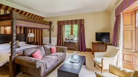 Fine & Country Scotland A luxury hotel room with four-poster bed, sofas and chairs