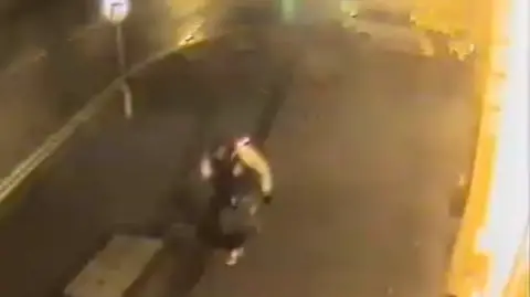 GMP Overhead CCTV footage shows Ahsan walking down a lit-up street at night