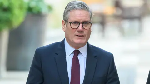 Reuters British Prime Minister Keir Starmer visits the Economic Crime Team at the City of London Police HQ wearing a suit