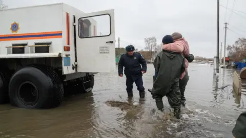 Getty Images Kazakh rescuers with victim in Pokrovka, North Kazakhstan