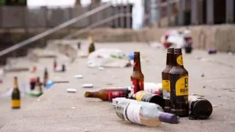 Bottles of wine and cider on the steps outside the Senedd
