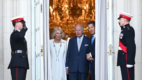 Samir Hussein via Getty Images Queen Camilla, King Charles III and Sir Christian Turner, British ambassador to the US, attend the White House garden party