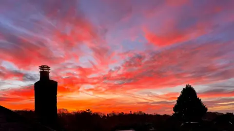 Bwanachana The sky is orange and deep blue, with some trails across it.