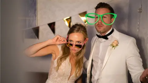 Getty Images A newlywed couple in a photo booth at their wedding reception