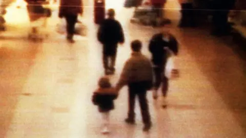 Getty Images Bulger was led out of the shopping centre by Venables and Thompson