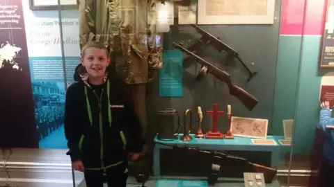 Handout James pictured as a young boy pictured at a museum display of a soldier's uniform and gun.