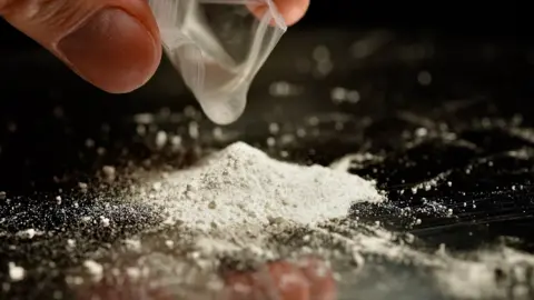 A pile of white powder on a black desk 